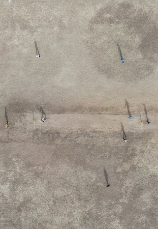 Aerial view of players playing cricket. Shadow play of crickets playing cricket. Drone view of...