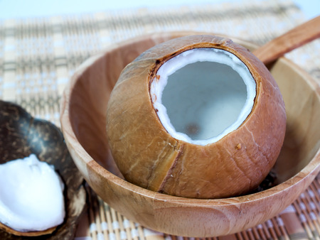 Coconut, cut out and placed on wooden bowl.