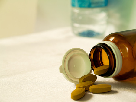 Medicines, put on the table and drinking water.の写真素材