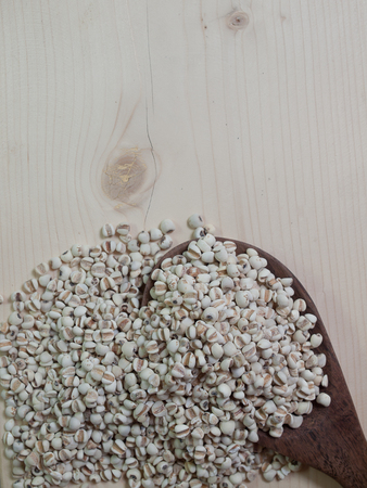 millet ,Placed on a wooden spoon on brown wood. (picture with space for text)の写真素材