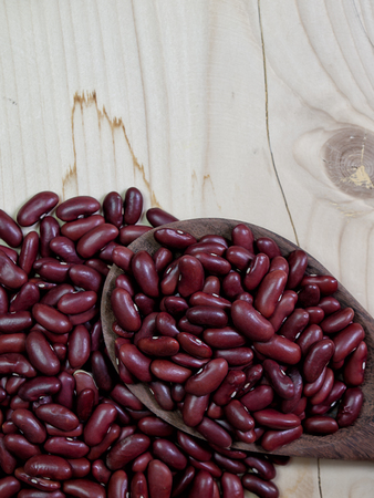 Red bean , Placed on a wooden spoon , on brown wood floor. (picture with space for text)