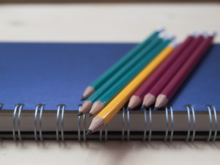 Pencil and book on wooden table,