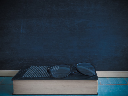 books and glasses , Blackboard, on the table in the classroom.の写真素材