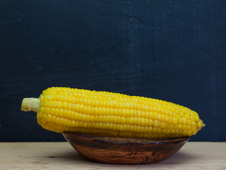Grains of ripe corn on wooden background. (with free space for text)の写真素材
