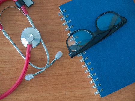 Office desk table with glasses and notebooks , Headphones medical , Health concept. .の写真素材