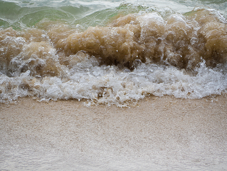Falling sea wave on a sandy shore, texture background.