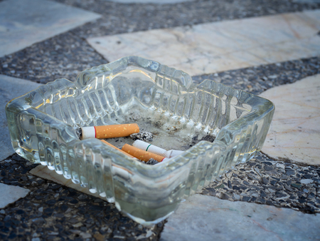(Close Up) Cigarette butts discarded in ashtray.の写真素材