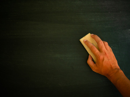 Hand holding brush eraser and blackboard , Concept education and school , background or copy space for add text message.の写真素材
