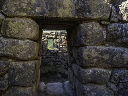 Ancient citadel. Houses and windows made with big blocks of rocks. Machu Picchu Archaeological Site, Cusco region, Peru.の写真素材