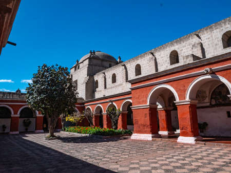 Inner courtyard in Saint Catherine Monastery, Arequipa city, Peru. Contrast of the tree surrounded by white walls of the monastery and the red walls that was the place where the nuns livedのeditorial素材