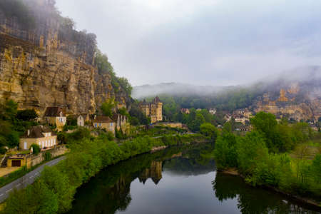 Aerial landscape of Chateau de la Mallantrie surrounded by fog and clouds. Village of La Roque Gageac, Dordogne river in Perigord zone, Franceのeditorial素材