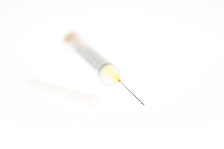 Einwegspritze mit KanÃ¼le und abgezogener Schutzkappe, geringe TiefenschÃ¤rfe - Single use syringe with needle and removed protection cap, shallow depth of fieldの写真素材