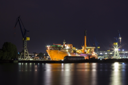 A large red ship in a Shipyard at night in the port of hamburgの写真素材
