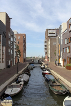 Modern residential area in Amsterdam with small canal and boatsの写真素材