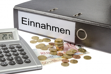 A Binder labeled wit the word Einnahme   German revenue  calculator and european currency の写真素材