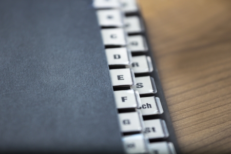 alphabetical registry on a black folder on a wooden table, shallow depth of field