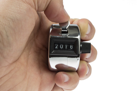 Hand held tally counter showing 2016 holded by male hand isolated on white backgroundの写真素材