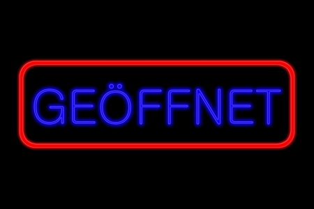Illuminated Neon sign with blue Letters and red frame showing geÃ¶ffnet (German: open) isolated on black backgroundの写真素材
