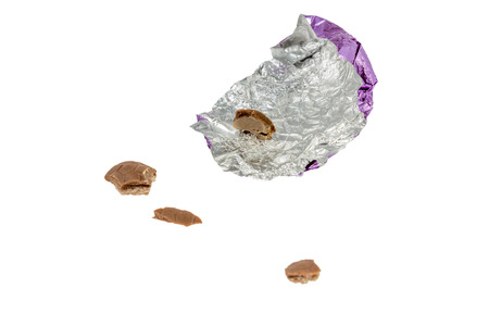 unwrapped eaten up chocolate easter egg isolated on white backgroundの写真素材