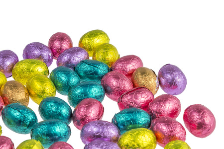 chocolate easter eggs wrapped in colorful aluminum foil isolated on white backgroundの写真素材