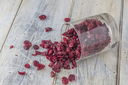 Dried Cranberries in a Glass on a wooden tableの写真素材