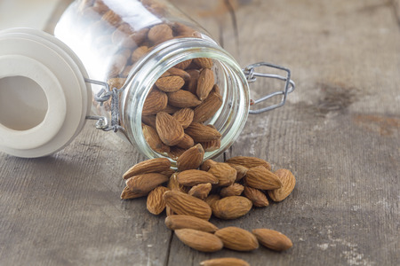 almonds in a jar on a wooden tableの写真素材