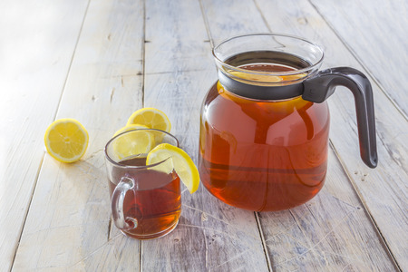 Can of fresh brewed ice tea with lemon on a white tableの写真素材