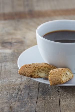 Traditional italian biscotti cookies with a cup of coffee on a wooden tableの写真素材