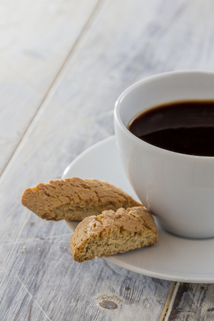 Traditional italian biscotti cookies with a cup of coffee on a wooden tableの写真素材