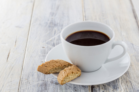 Traditional italian biscotti cookies with a cup of coffee on a wooden tableの写真素材