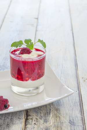 Raspberry Cream in a glass on a wooden tableの写真素材