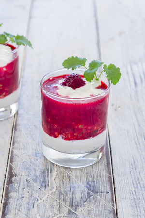 Raspberry Cream in a glass on a wooden tableの写真素材