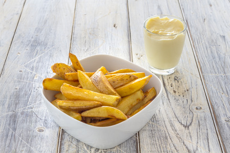 home made french fries and mayonnaise on a wooden tableの写真素材