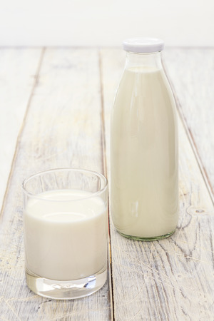 Bottle and a glass of Milk on a wooden tableの写真素材