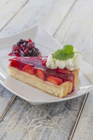 Slice of homemade strawberry cake with whipping cream on a white plateの写真素材