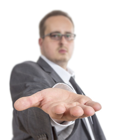 Business man reaches out his arm holding his hand directly into the camera. Isolated on White Backgroundの写真素材