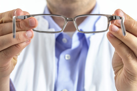 An optician handing out glasses seen from the patients point of viewの写真素材