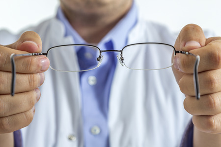An optician handing out glasses seen from the patients point of viewの写真素材