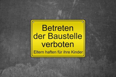 Illustration of a typical german construction site sign "Betreten der Baustelle verboten" (German Do not enter the construction site, parents are liable for their children), on a concrete wallの写真素材