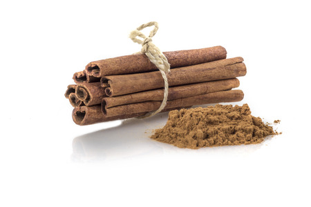 Bundle of Cinnamon Sticks and cinnamon powder isolated on white backgroundの写真素材