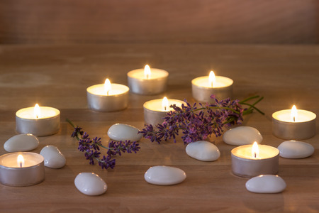 Tea Candles with white stones and lavender on rustic wooden backgroundの写真素材