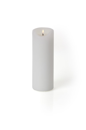 A burning candle isolated on white background with light shaddow and reflectionの写真素材