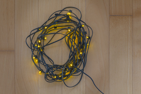 Rolled Electric christmas tree lights on wooden floorの写真素材