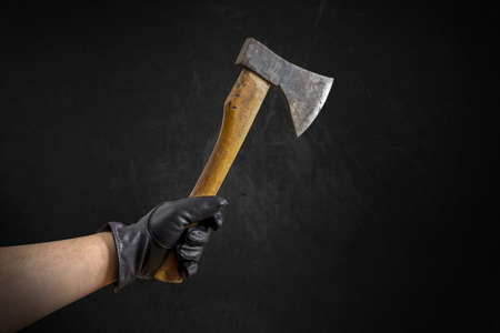 An Arm with black leather gloves holding a small axeの写真素材