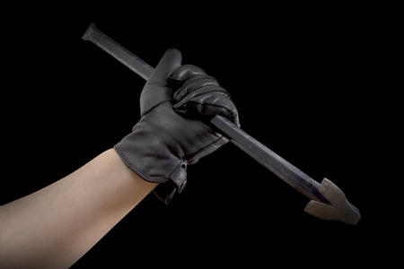 A Hand in black leather gloves holding a cow barの写真素材