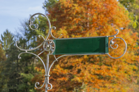Historic directory sign with orange colored tree druring autumnの写真素材