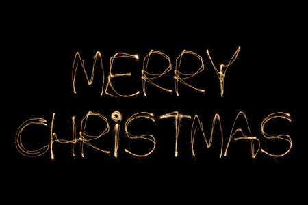 Merry Christmas written with a sparkler isolated on black backgroundの写真素材