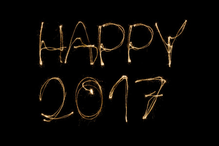 Happy 2017 written with a sparkler isolated on black backgroundの写真素材