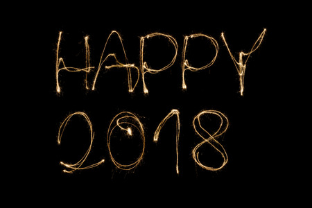 Happy 2018 written with a sparkler isolated on black backgroundの写真素材