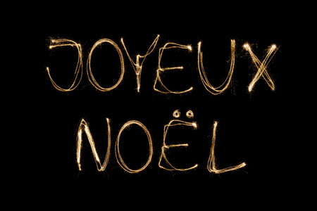 Joyeux Noel (French Merry Christmas) written with a sparkler isolated on black backgroundの写真素材